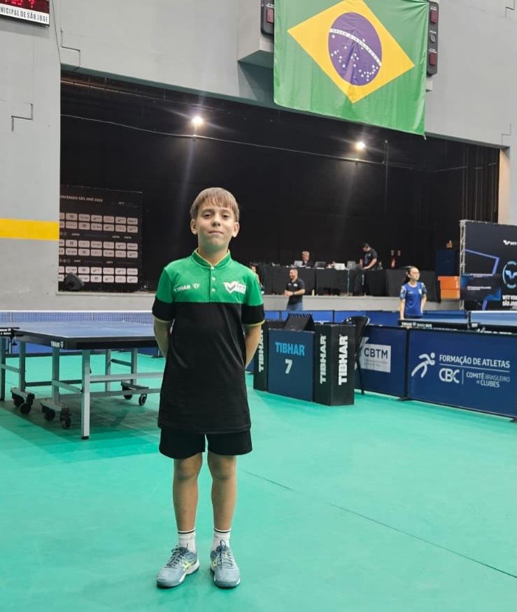 Miguel na arena do torneio, com a bandeira do Brasil ao fundo